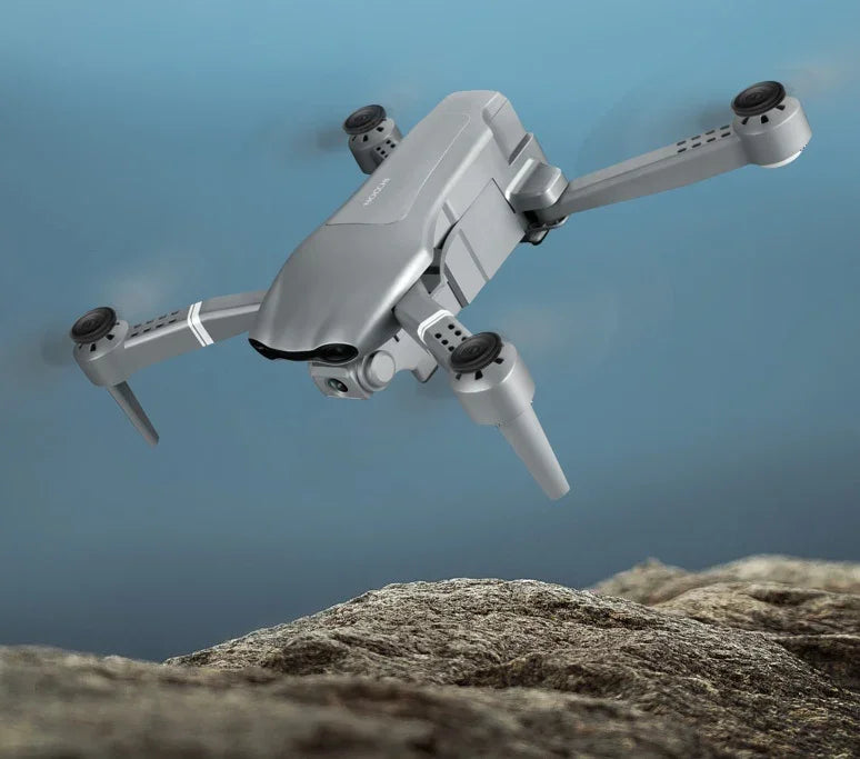 Drone gris volando sobre rocas, tecnología avanzada para fotografía aérea profesional